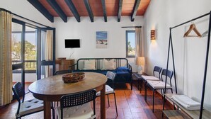 A room with a round table, chairs, a sofa, a TV, and a window with curtains. - Pedras del Rei 8 (Pedrinhas del Rei) (Santa Luzia)