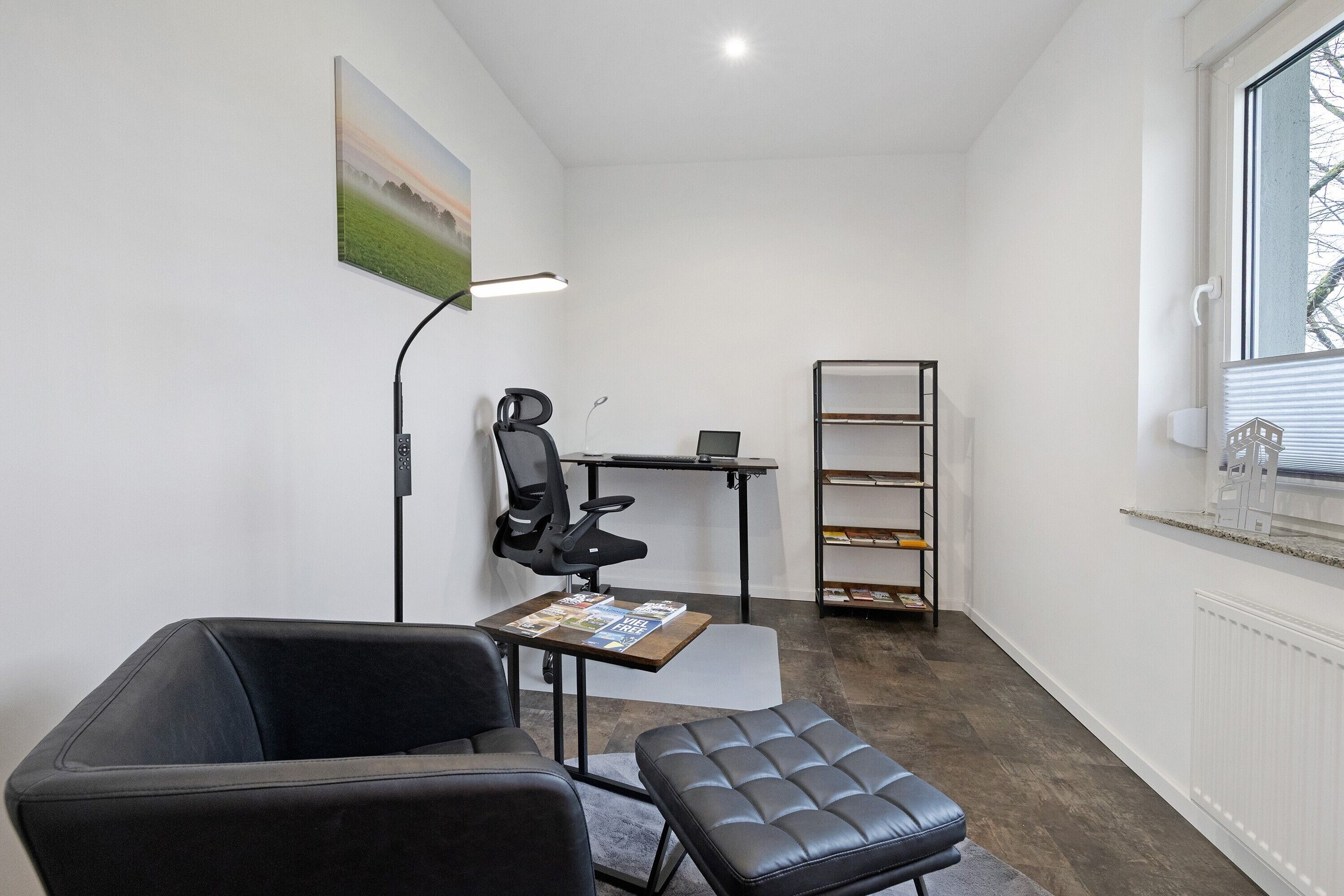 Un espacio de oficina moderno con un escritorio, una silla y estanterías.