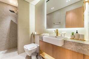 Un baño moderno con ducha, inodoro, lavamanos y tocador.