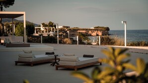 Eine Strandlounge mit Sitzgelegenheiten im Freien und Blick auf das Meer.
