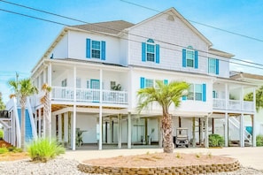 A two-story house with a balcony, a covered porch, and a driveway. - Pelican Manor D (North Myrtle Beach)