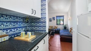 A kitchen with blue and white tiles, a sink, and a countertop with a tray and cups.