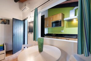 Cocina con armarios de madera, microondas y campana extractora.