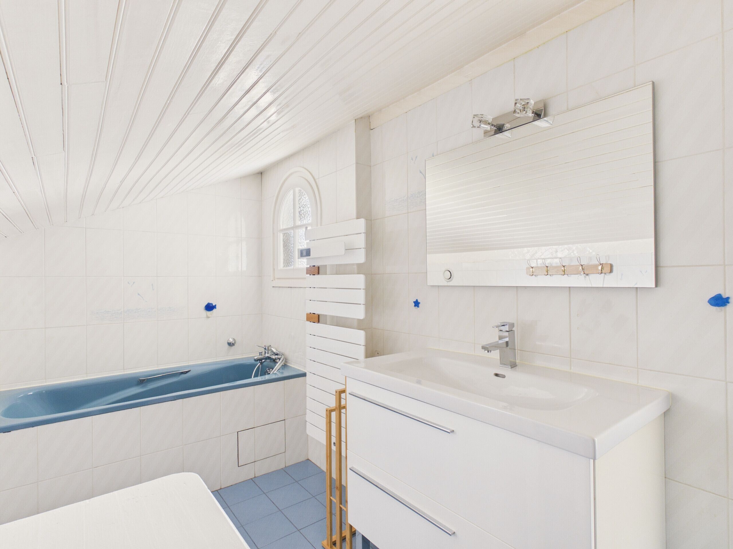Een moderne badkamer met een badkuip, een wastafel en een badkamerkast.