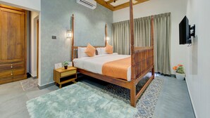 A four-poster bed with a wooden frame, a nightstand with a lamp, and a potted plant. - ELIVAAS Breeze & Grains 3BHK with Patio (Kuttanad Taluk)