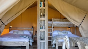 A tent with two beds, a ladder, and shelves with books and items. - Orla Ilha de Tavira Eco-Glamping (Tavira)