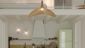 A modern kitchen with a central island, a hanging light fixture, and a two-story layout. - Veggera Living Tinos (Tinos)