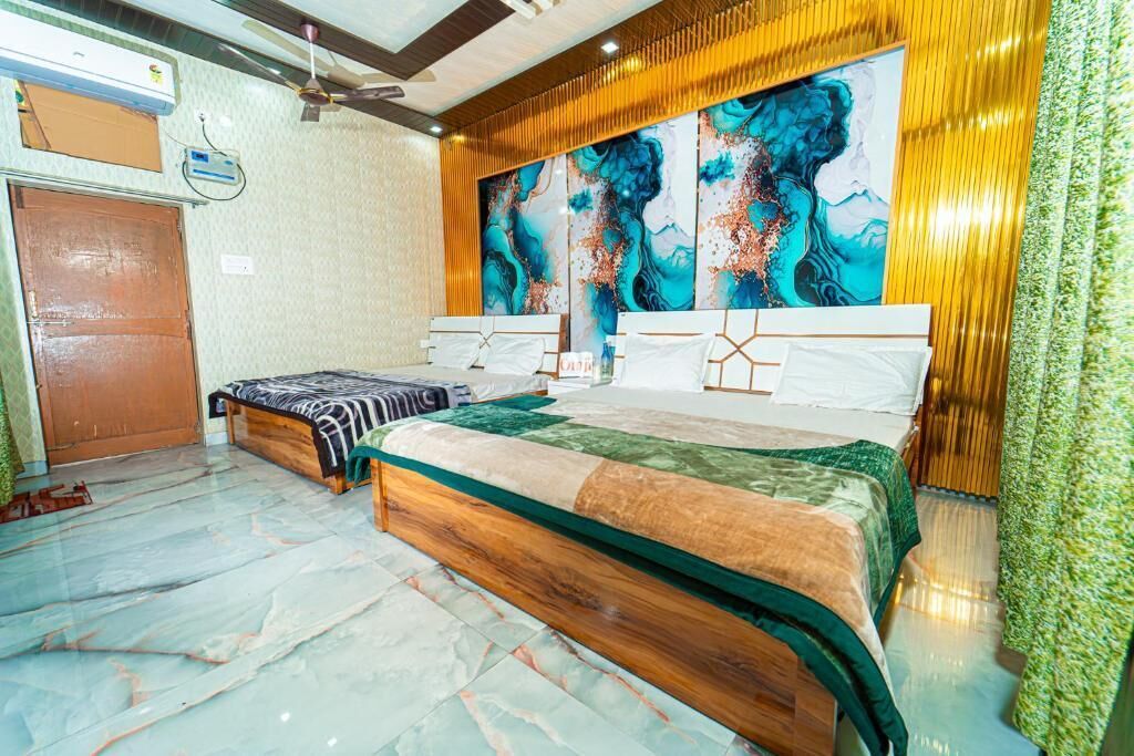 A hotel room with a large bed, a smaller bed, a wooden headboard, a ceiling fan, and a large abstract painting on the wall.