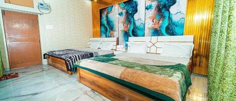 A hotel room with a large bed, a smaller bed, a wooden headboard, a ceiling fan, and a large abstract painting on the wall.