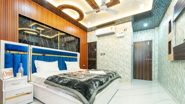 Ein modernes Schlafzimmer mit Bett, Nachttischen, Deckenventilator und Wand-Fernseher.
