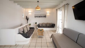 A living room with a white sofa, a wooden coffee table, and a grey sofa. - Villa THEA Myconian Vision Villas (C9GQ+Q6 Ελιά, Greece)