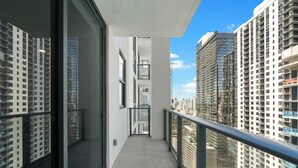 A modern building with a balcony, large windows, and a view of surrounding high-rise buildings. - 2BR Near Bayside Market | Gym & Sauna (Miami)