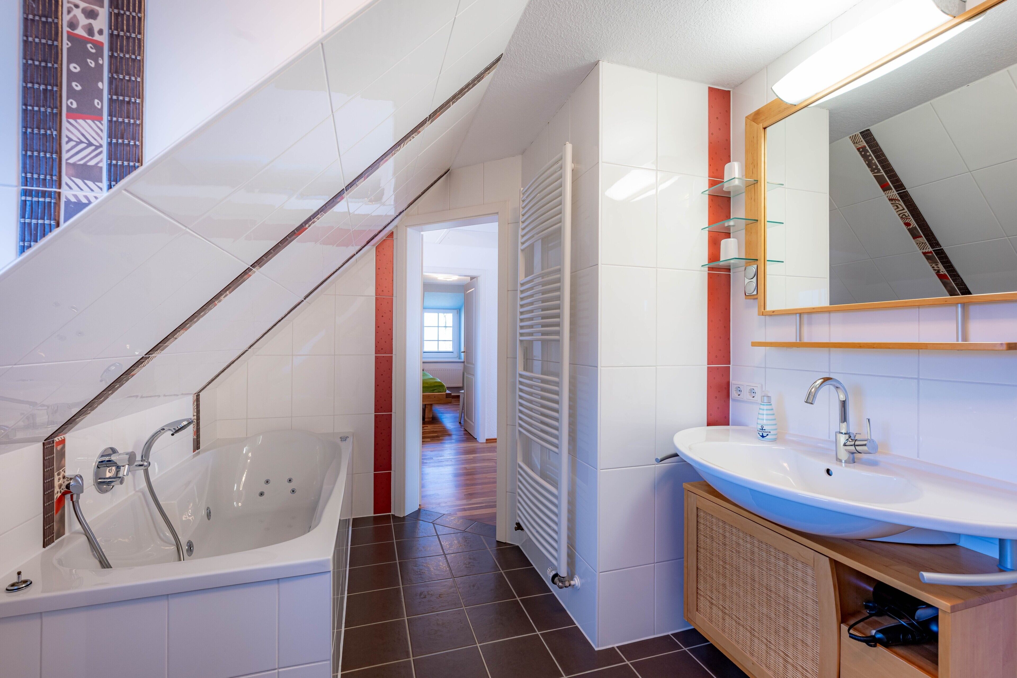 A modern bathroom with a bathtub, a sink, and a mirror.
