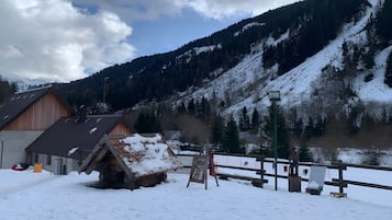 Un paysage montagneux enneigé, avec une cabane en bois et une clôture en bois.