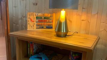 Una estantería de madera con una lámpara, un ábaco y recipientes de almacenamiento.