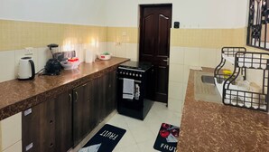 Una cucina con piano cottura, macchina del caffè e frigorifero.