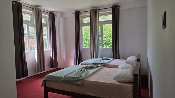 A room with two beds, a red carpet, and curtains on windows. - Mellow Breeze - Serene 3-bedroom bungalow in charming Nuwara Eliya (Nuwara Eliya)