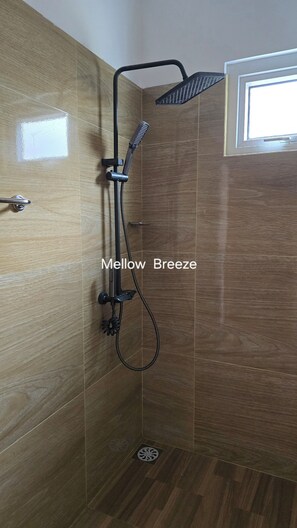A shower with a handheld showerhead and a wall-mounted head, a window, and a door with a handle. - Mellow Breeze - Serene 3-bedroom bungalow in charming Nuwara Eliya (Nuwara Eliya)