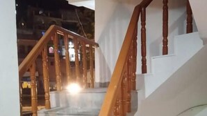 A staircase with wooden balusters and a handrail, leading to an upper floor. - Hotel shivdev (Uttarkashi)