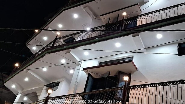 A multi-story building with balconies and multiple windows. - Hotel shivdev (Uttarkashi)