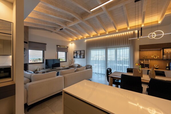 A modern living space with a kitchen, dining area, and seating area. - Vivere Suites (Nafplio)