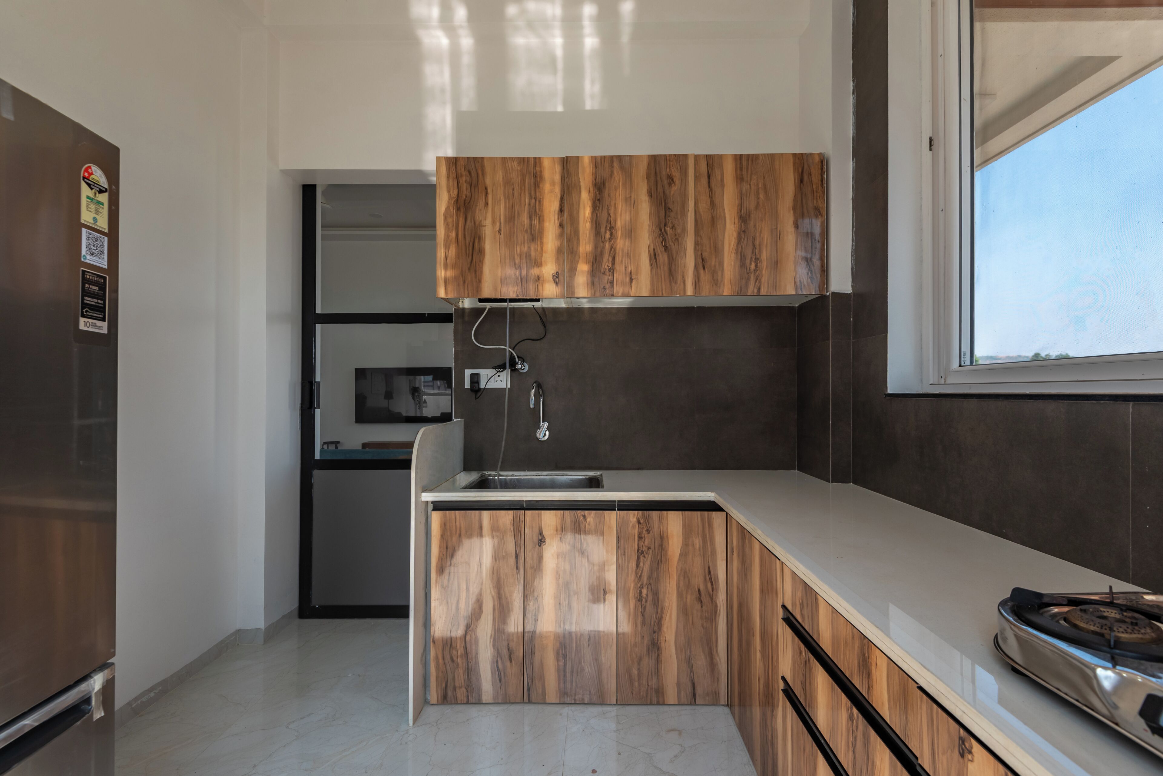 Una cocina moderna con estufa integrada, un lavamanos y armarios de madera.