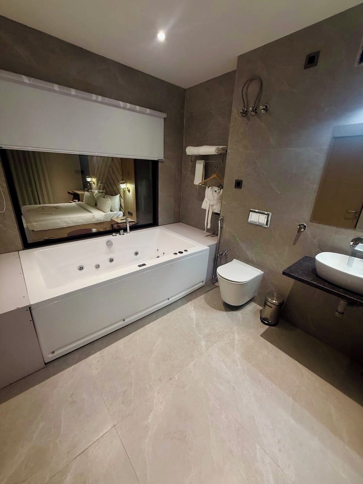 Un baño moderno con una bañera grande, un lavamanos independiente y un espejo.