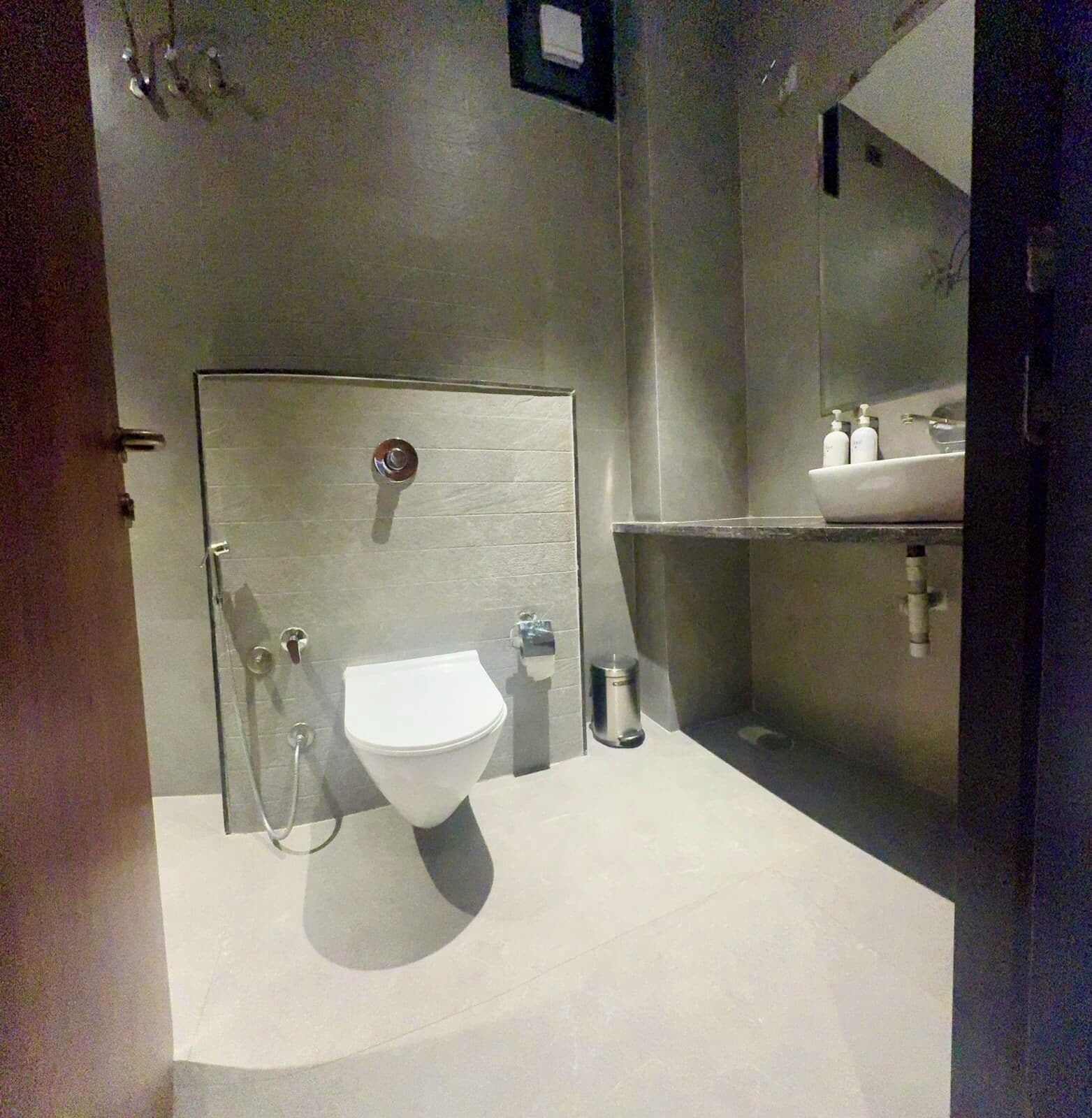 Une salle de bain moderne équipée de toilettes, d’une douche et d’un lavabo.