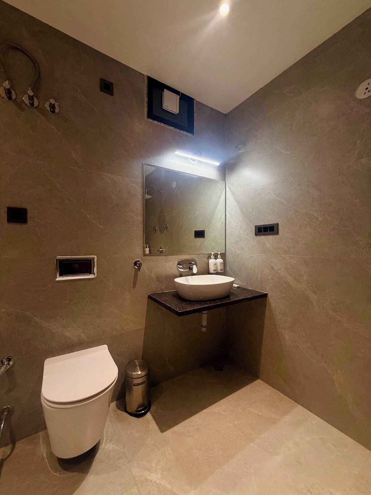 A modern bathroom with a toilet, sink, and shower.