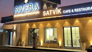 En bygning med et skilt, der viser 'RIVERA' og 'SATVIK CAFE & RESTAURANT'.