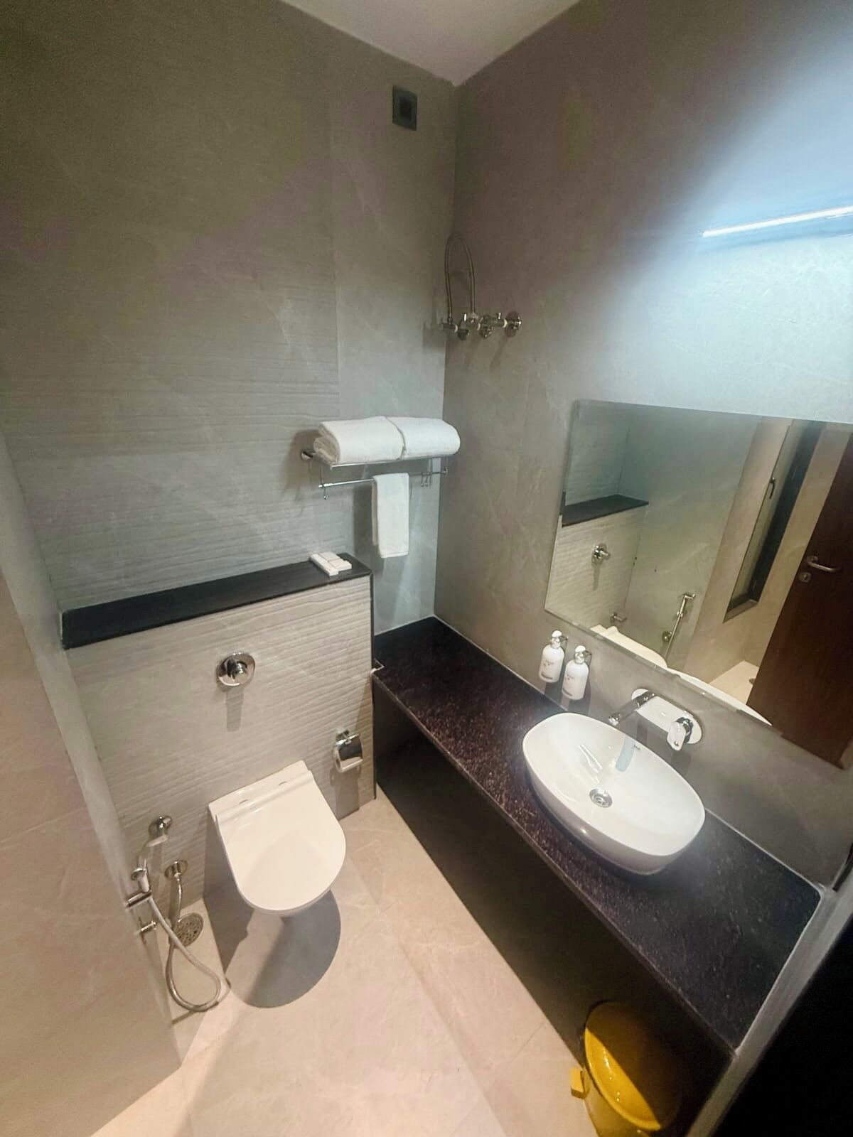 A modern bathroom with a toilet, sink, and shower.
