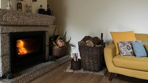 Un salon avec une cheminée, un canapé jaune et des objets de décoration.