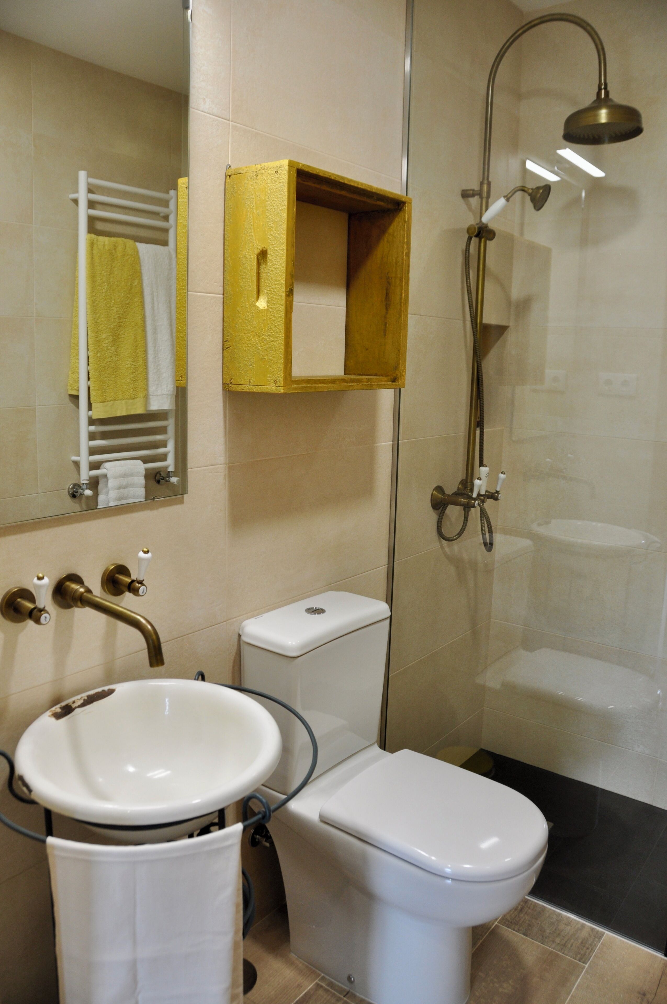 A bathroom with a sink, toilet, shower, and a mirror.
