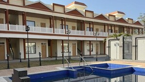 Un hôtel doté d’une piscine, de nombreux balcons et d’une architecture moderne.
