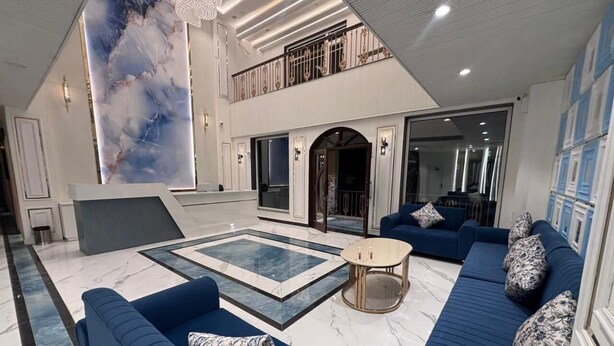 Un vaste espace de vie avec une piscine, des canapés bleus et un design moderne.