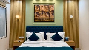 Une chambre à coucher comprenant un lit, un ventilateur de plafond, un éclairage encastré, une œuvre d’art accrochée au mur et deux lampes de chevet.
