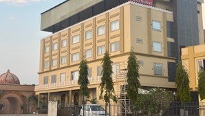 Un hôtel à plusieurs étages, reconnaissable à son grand panneau indiquant : « The Grand Ma’an Palace Hotel & Restaurant ».