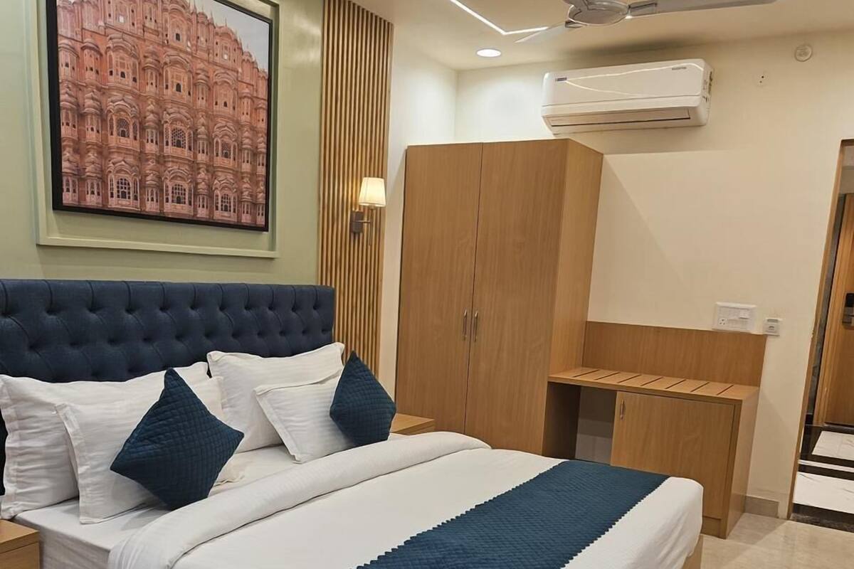 Une chambre moderne équipée d’un lit, d’une armoire, d’un bureau et d’un appareil de climatisation.