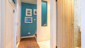 Un corridoio con una parete blu, una porta in legno e una piccola finestra.