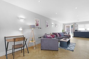 Una sala moderna con un sofá, una mesa de centro y un escritorio con una silla.