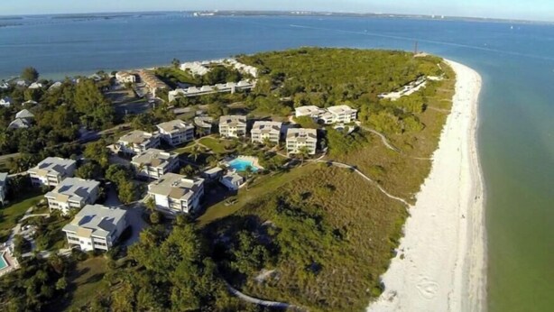 Een kustresort met strandvilla's, een zwembad en uitzicht op de oceaan.