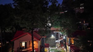 A multi-story building with a red roof, a balcony, and a staircase leading to an upper level. - Alaya Stays 3BHK Golden Meadow Villa (Kasauli)