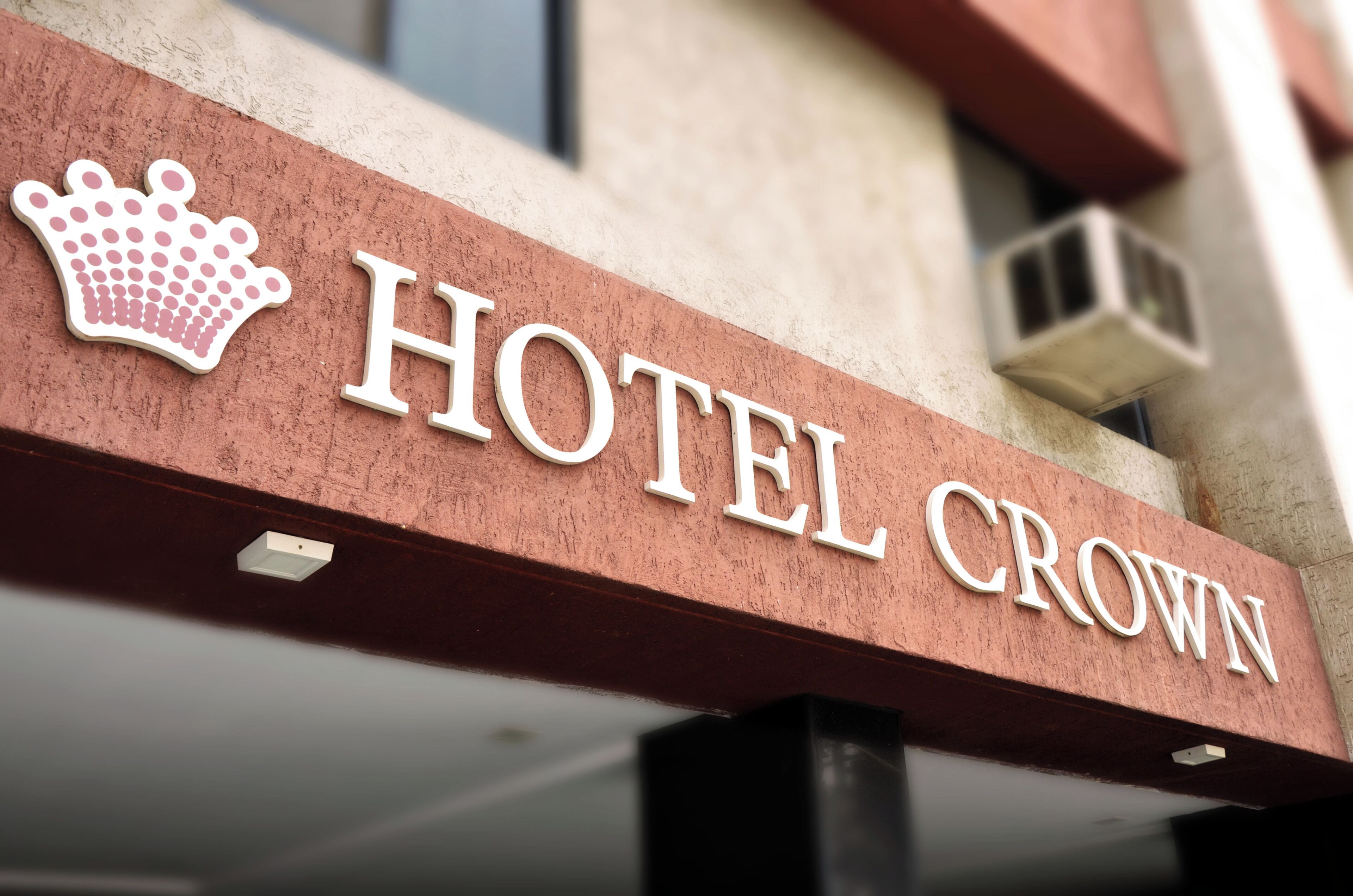 A hotel sign with a crown symbol and the name 'HOTEL CROWN'.