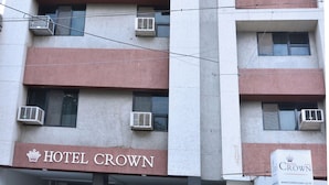 A multi-story building with the sign 'HOTEL CROWN' at the ground level. - Hotel Crown (Rajkot)