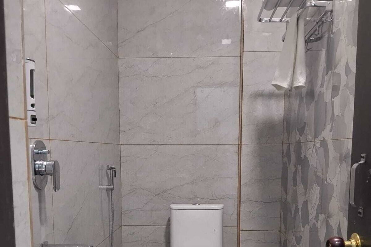 Een badkamer met toilet, wastafel en douche.