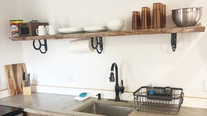 A kitchen with wooden cabinets, a stainless steel sink, a wooden countertop, and a shelf with kitchenware. - Perfect Studio - Walking distance of Lava Hot Springs Pools (Lava Hot Springs)