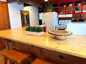 Eine Küche mit Holzausschlag, einem Blumentopf, einem weißen Kühlschrank und einem Herd.