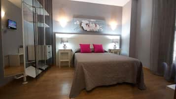 A bedroom with a bed, two bedside tables, a wall-mounted artwork, and a staircase.