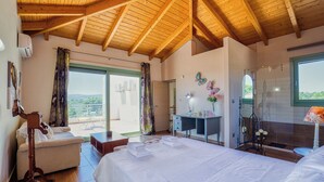 A bedroom with a bed, a desk, a chair, a vanity, and a large window. - Elia country villa 5BR 5BA with Private Pool (Megara)