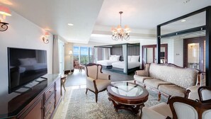 A spacious living room with a flat-screen TV, a round coffee table, and a large sofa. - Oriental Hotel Okinawa Resort and Spa (Nago)